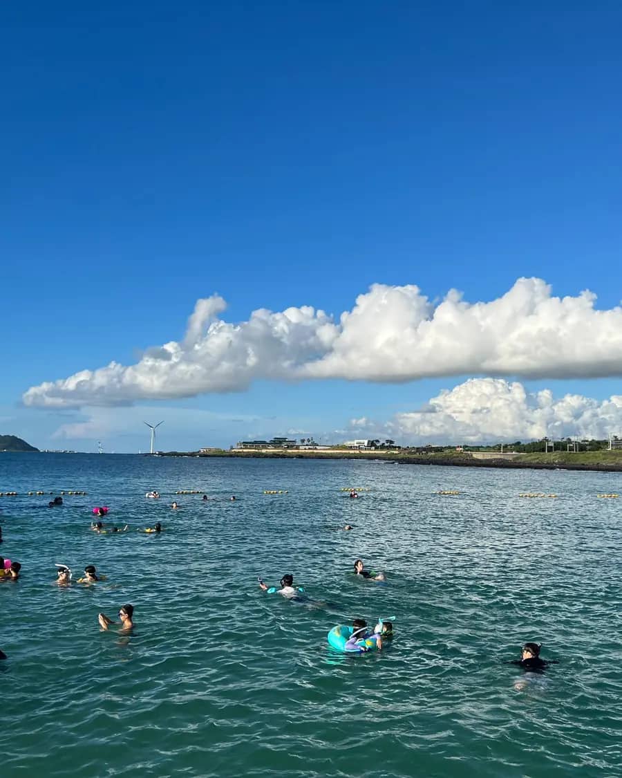 People swimming close to shore at Panpo Port in summer