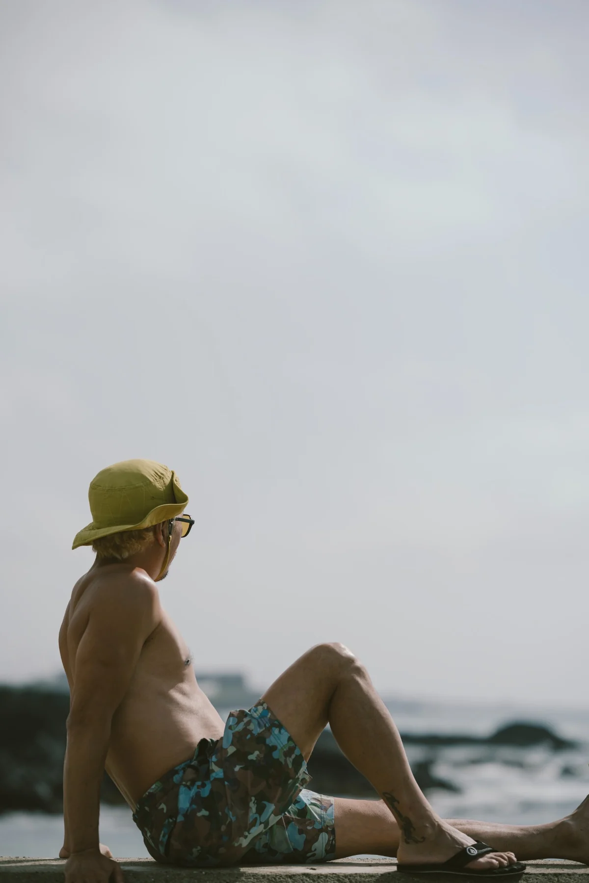 A side portrait of Lee Deokwon looking out to sea on the Wollyeong coast