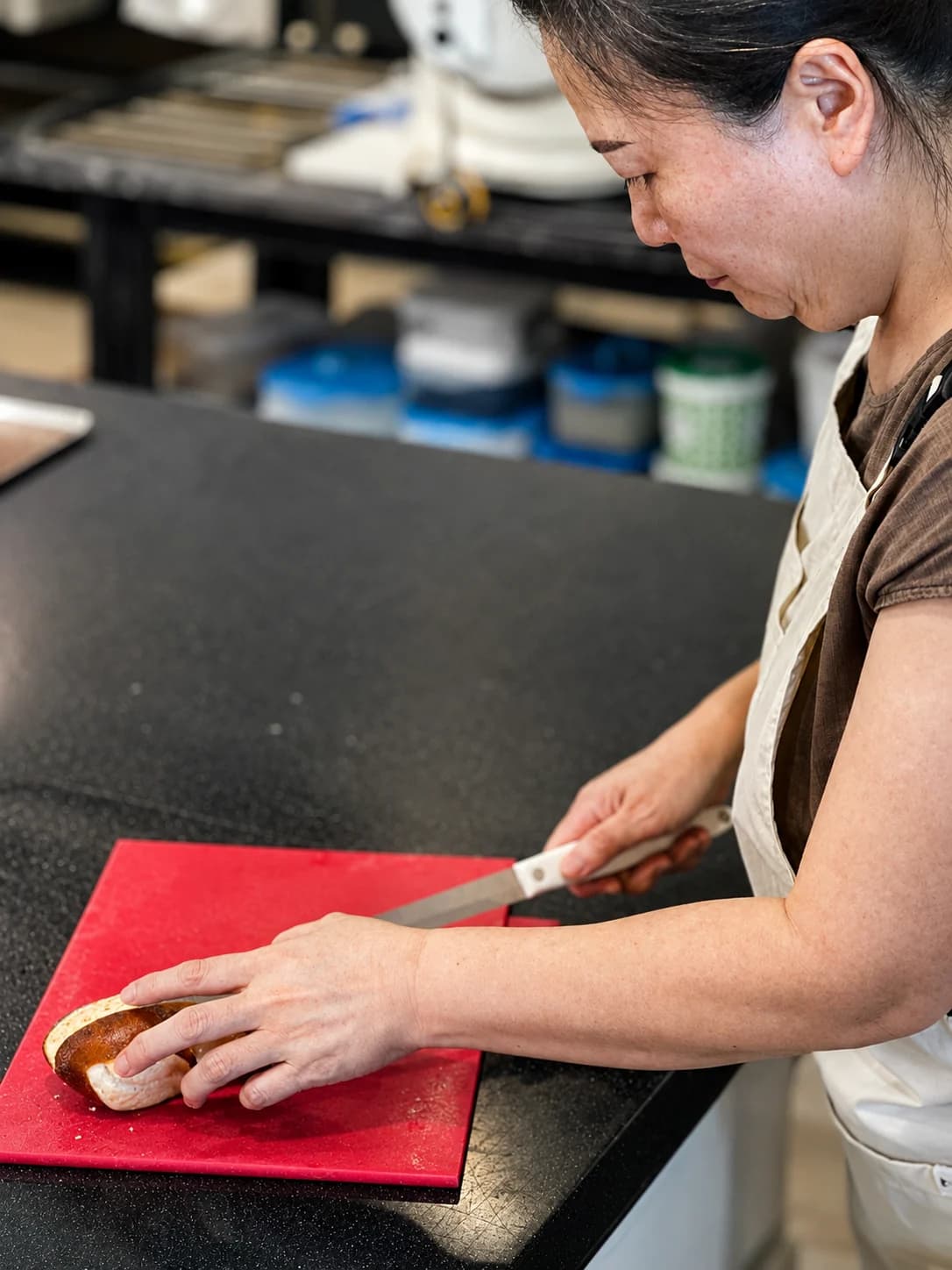 Lee Kyungsoon cutting bread at a worktable
