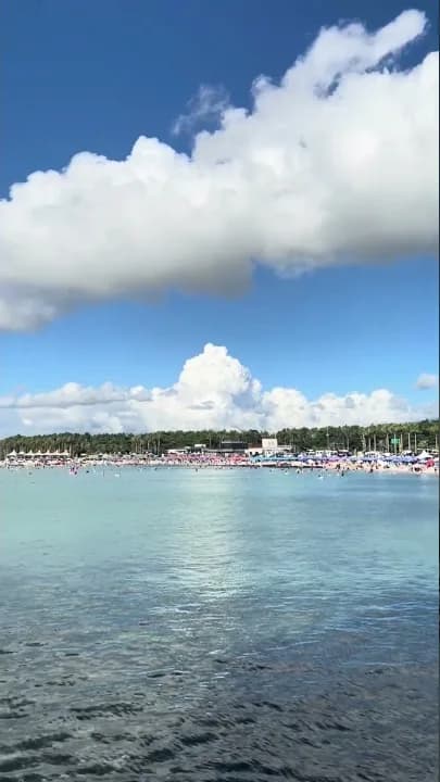 Clear summer water at Hyeopjae Beach beneath a blue sky and white clouds