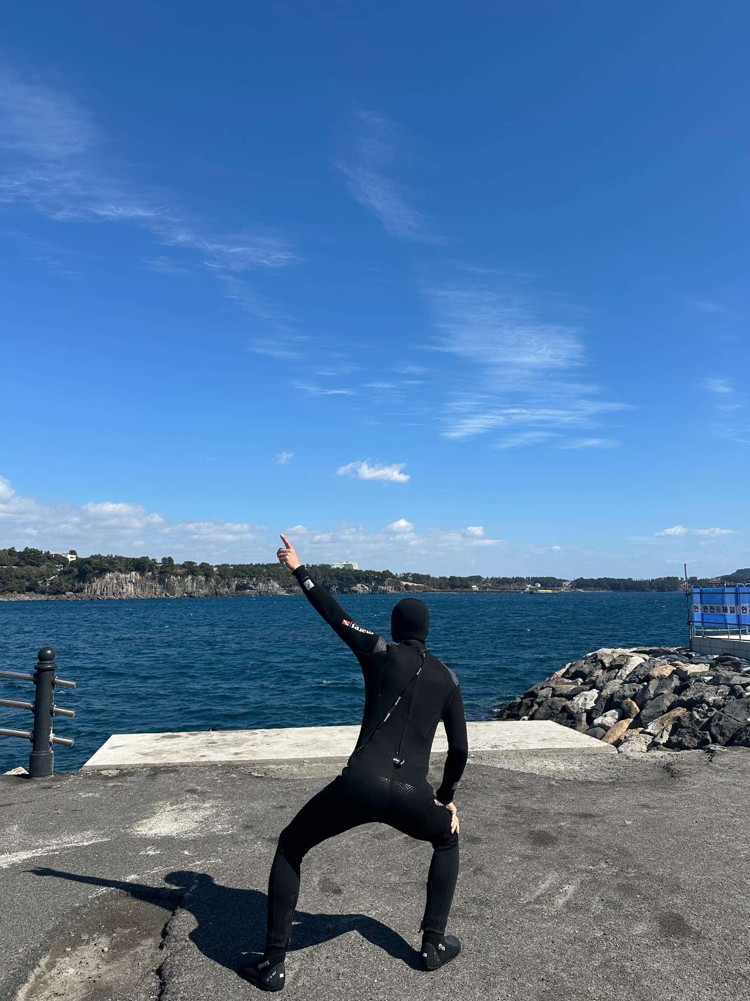 A diver stretching beside the blue sea in Jeju