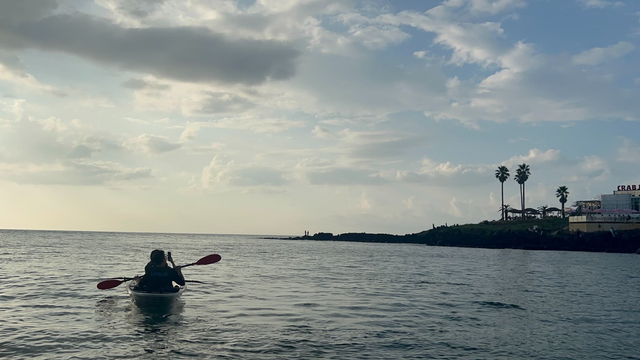 A person kayaking on the sea off Jeju at dusk