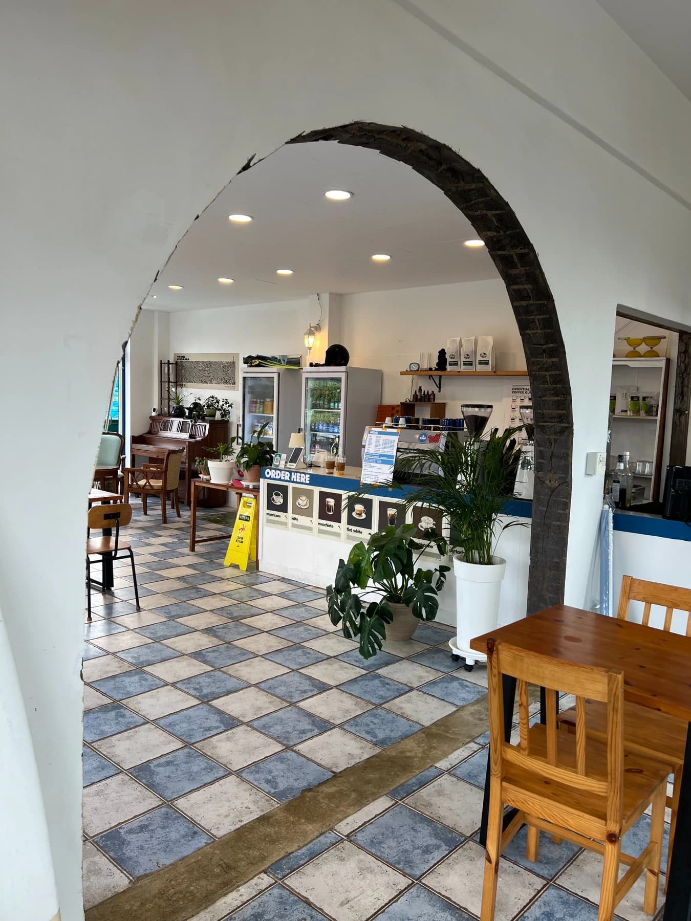 The Wolyeong Port counter, plants and tiled floor seen through an interior arch
