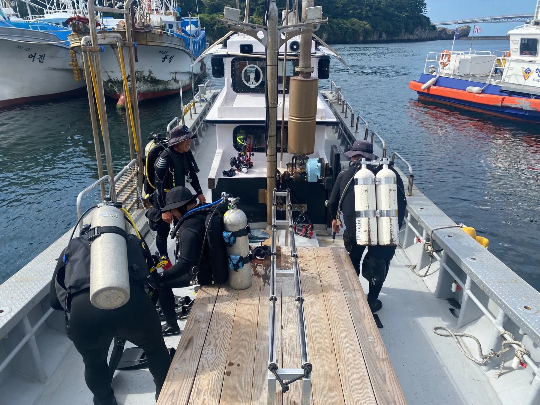 Divers preparing scuba equipment aboard a boat