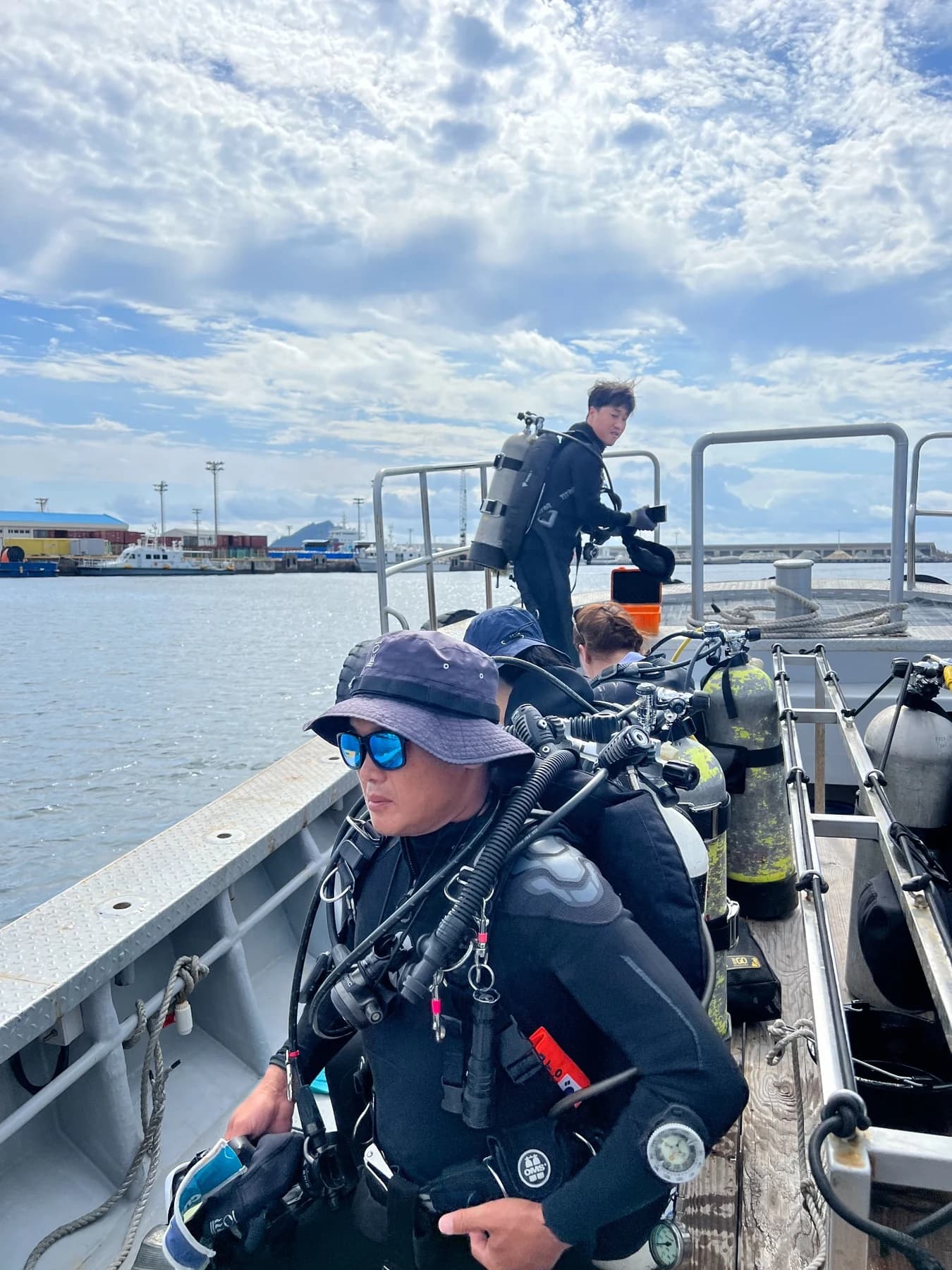 A diver wearing scuba equipment and preparing to enter the water from a boat