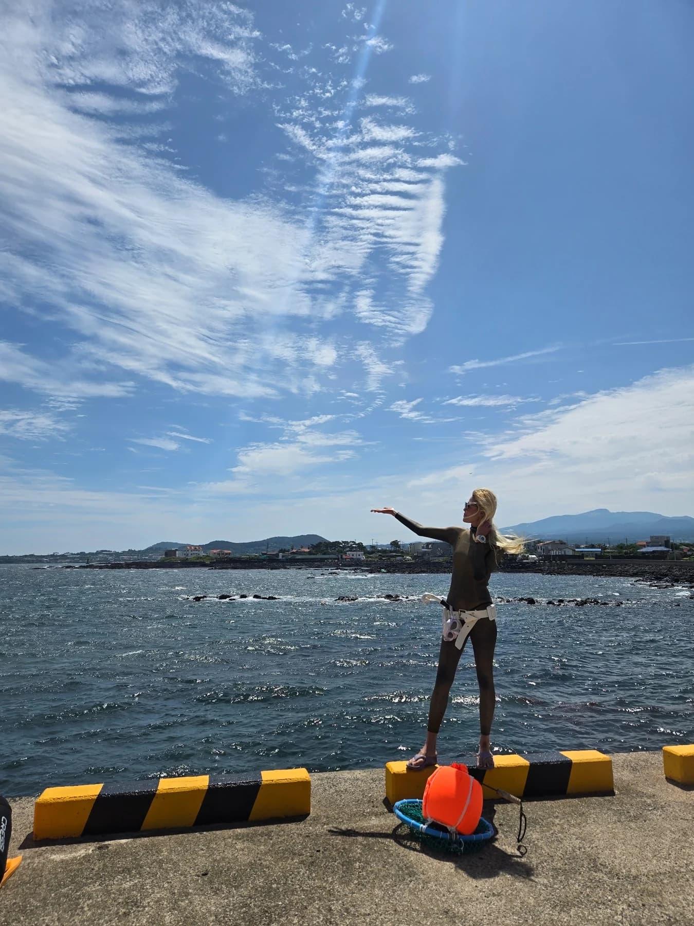 Seol Jinmi standing by the Jeju coast with equipment for the sea