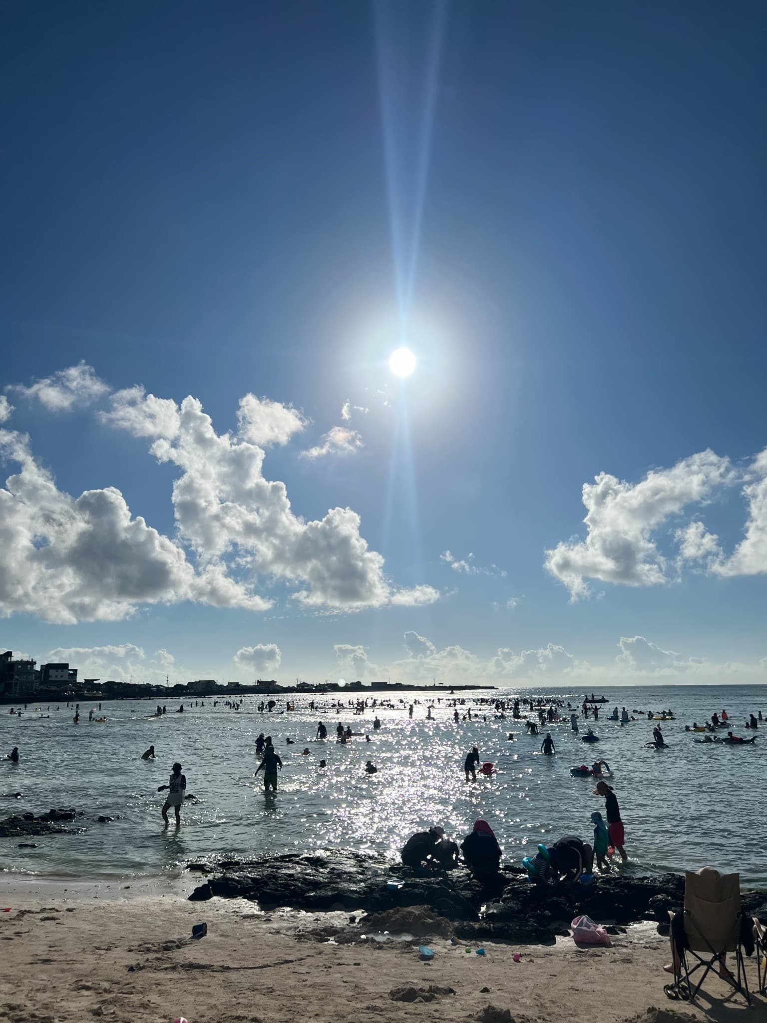 Visitors swimming at Hyeopjae Beach during the summer season